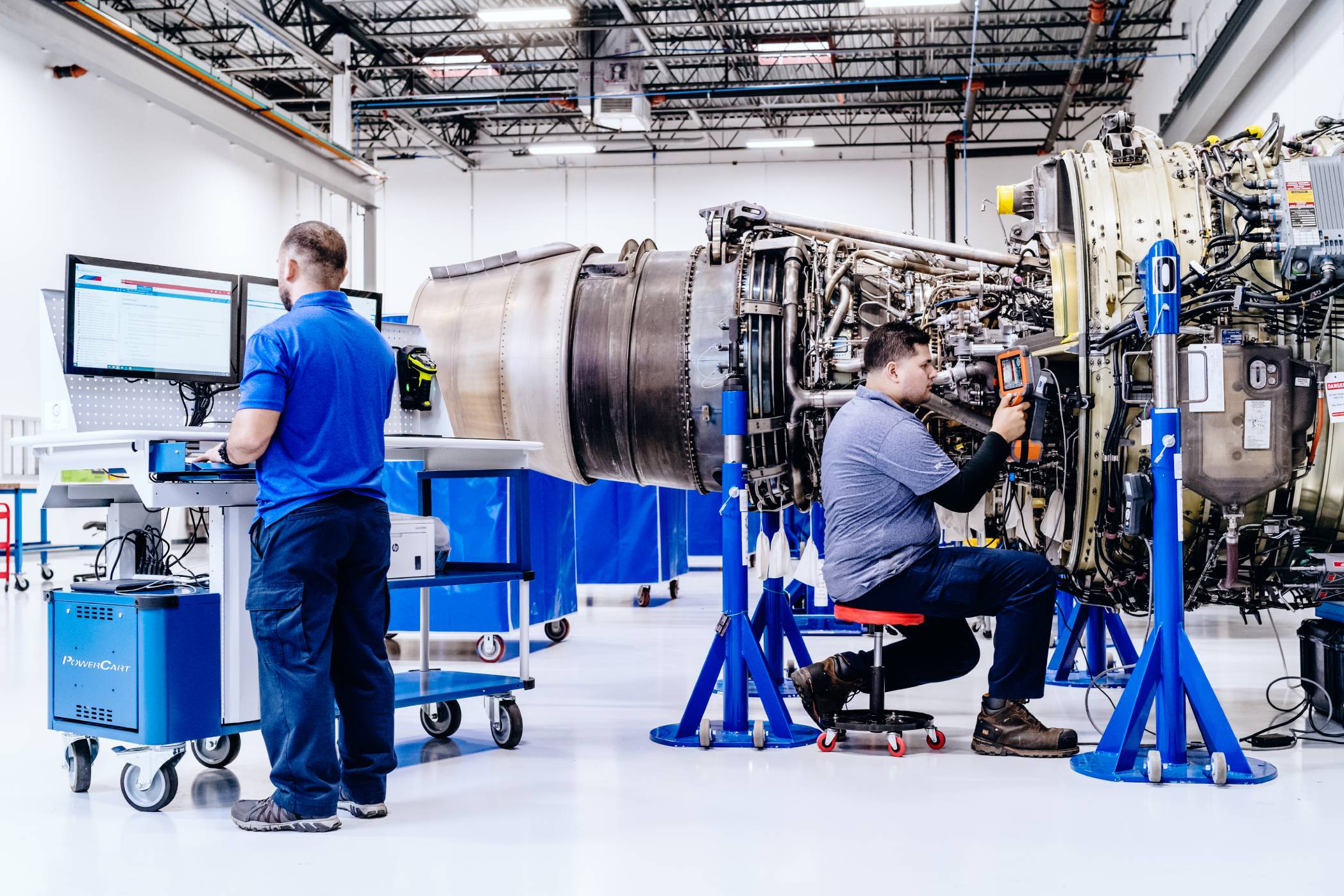 Two Willis engine technicians perform diagnostic maintenance on a stand mounted engine using the latest tools and techniques