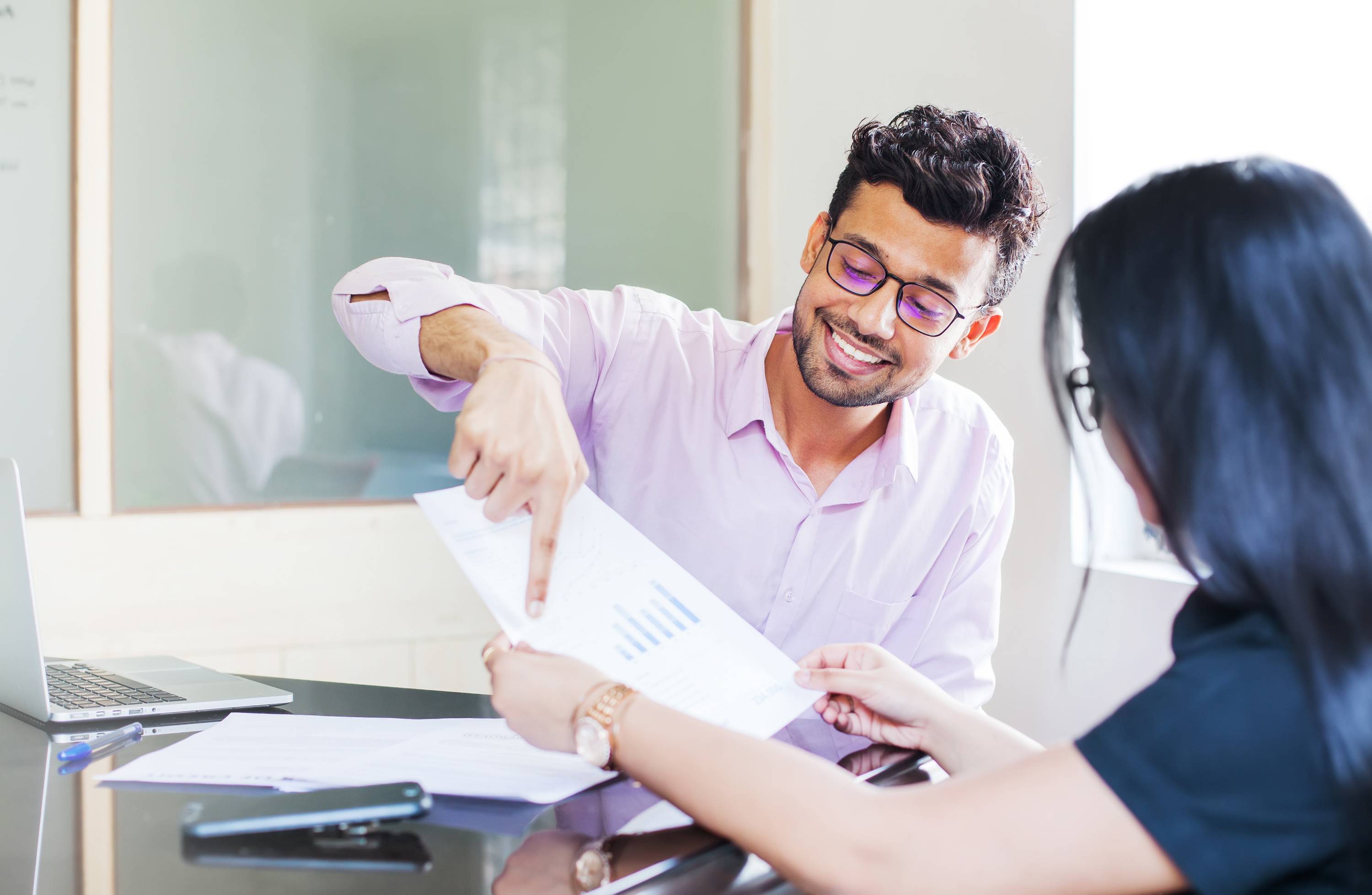 Willis team members review a spreadsheet. Corporate governance ensures business operations and upholds shareholder interests.